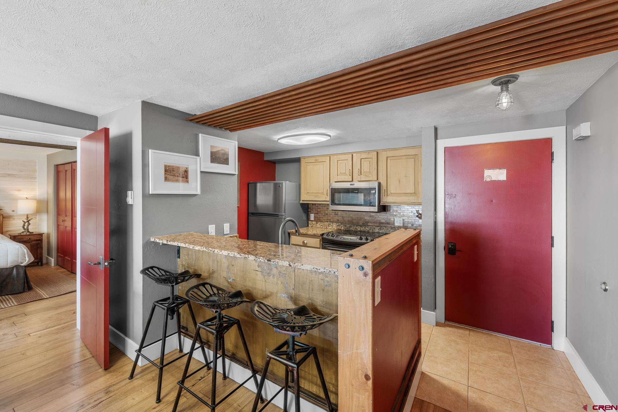 651 Gothic Road, Unit 505 Crested Butte, CO 81225 - Photo 22 of 44 a kitchen with stainless steel appliances granite countertop a stove and a refrigerator