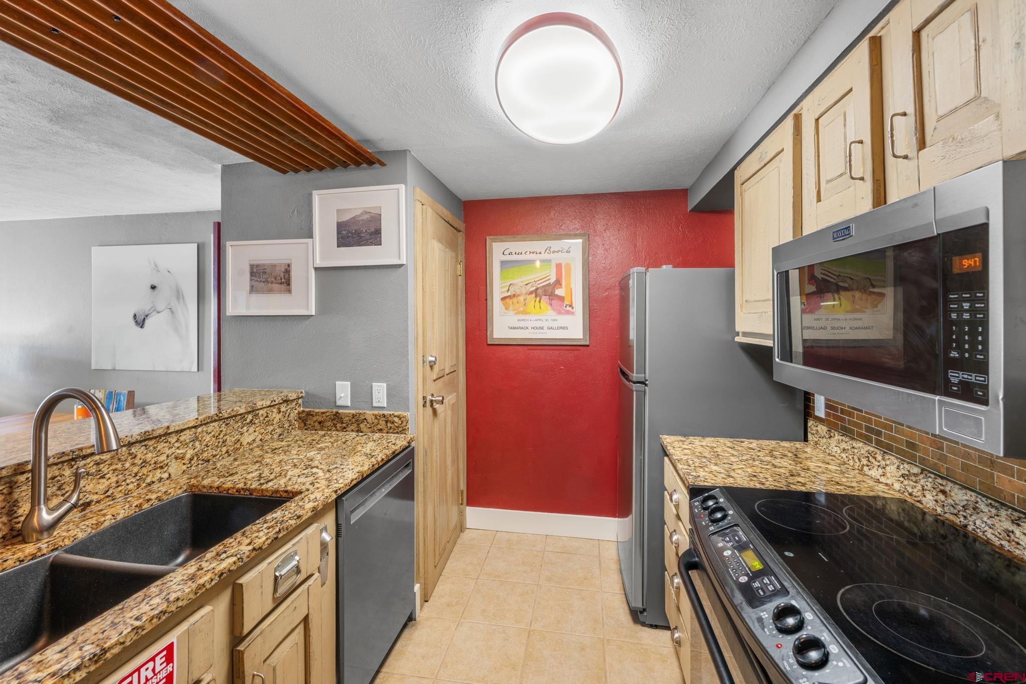 651 Gothic Road, Unit 505 Crested Butte, CO 81225 - Photo 23 of 44 a kitchen with stainless steel appliances granite countertop a stove and a microwave