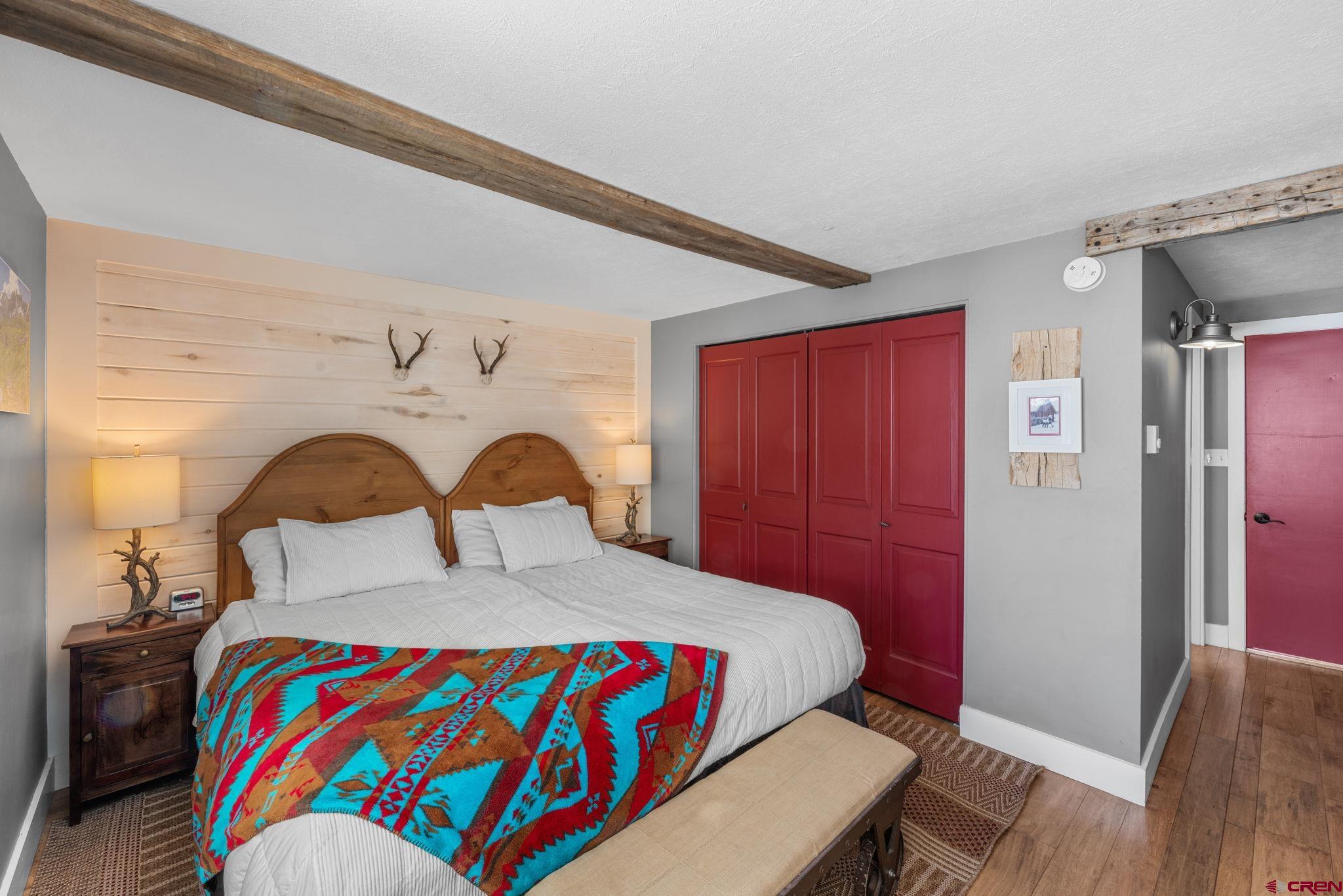 651 Gothic Road, Unit 505 Crested Butte, CO 81225 - Photo 9 of 44 a bedroom with a bed and dresser with wooden floor