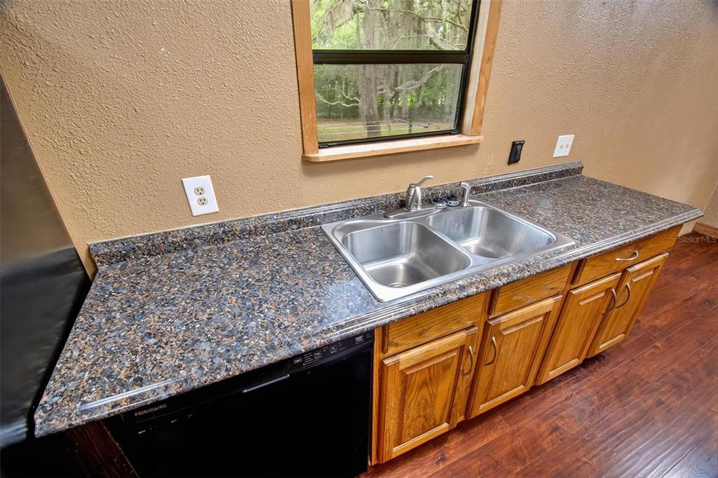 156 Kingfish Road Pomona Park, FL 32181 - Photo 31 of 55 a kitchen with granite countertop a sink and a wooden floor
