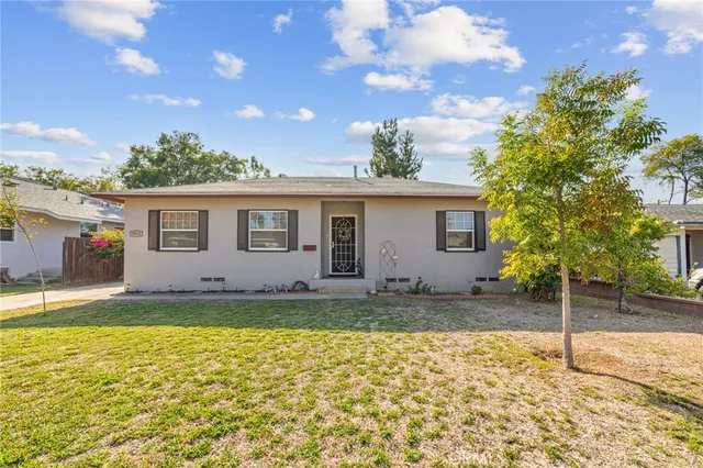 a view of a house with a backyard and a tree