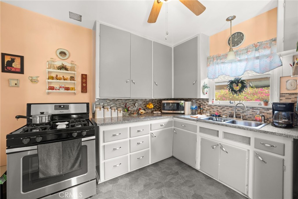 3924 Wayne Court Riverside, CA 92504 - Photo 18 of 31 a kitchen with white cabinets and appliances