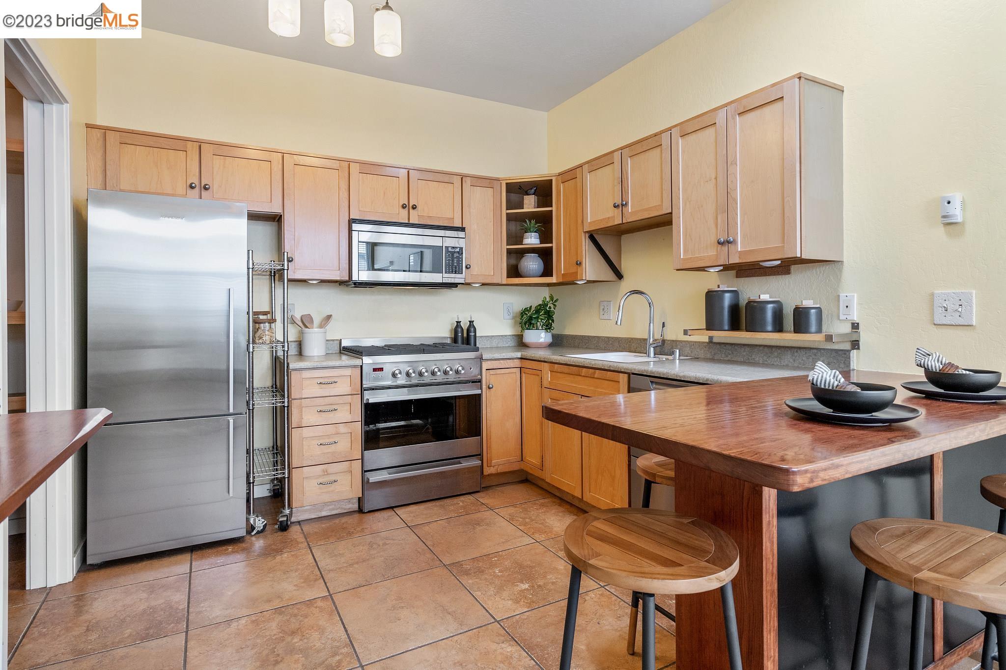 a kitchen with stainless steel appliances granite countertop a stove a sink and a refrigerator