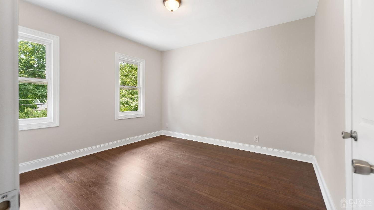718 Front Street Dunellen, NJ 08812 - Photo 23 of 28 an empty room with wooden floor and windows