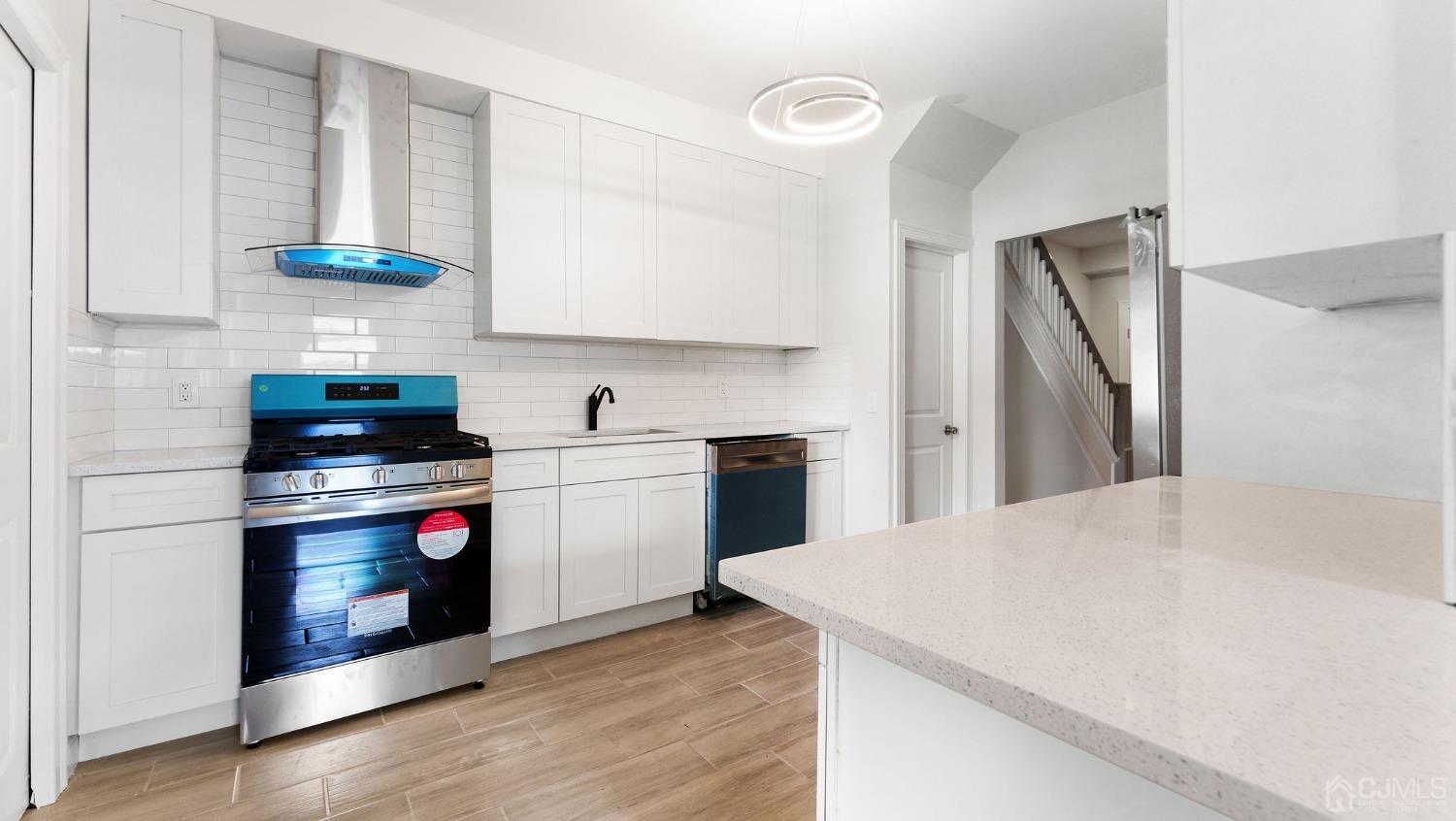 718 Front Street Dunellen, NJ 08812 - Photo 8 of 28 a kitchen with a sink a stove and cabinets