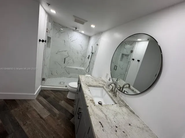 a bathroom with a sink a toilet and shower