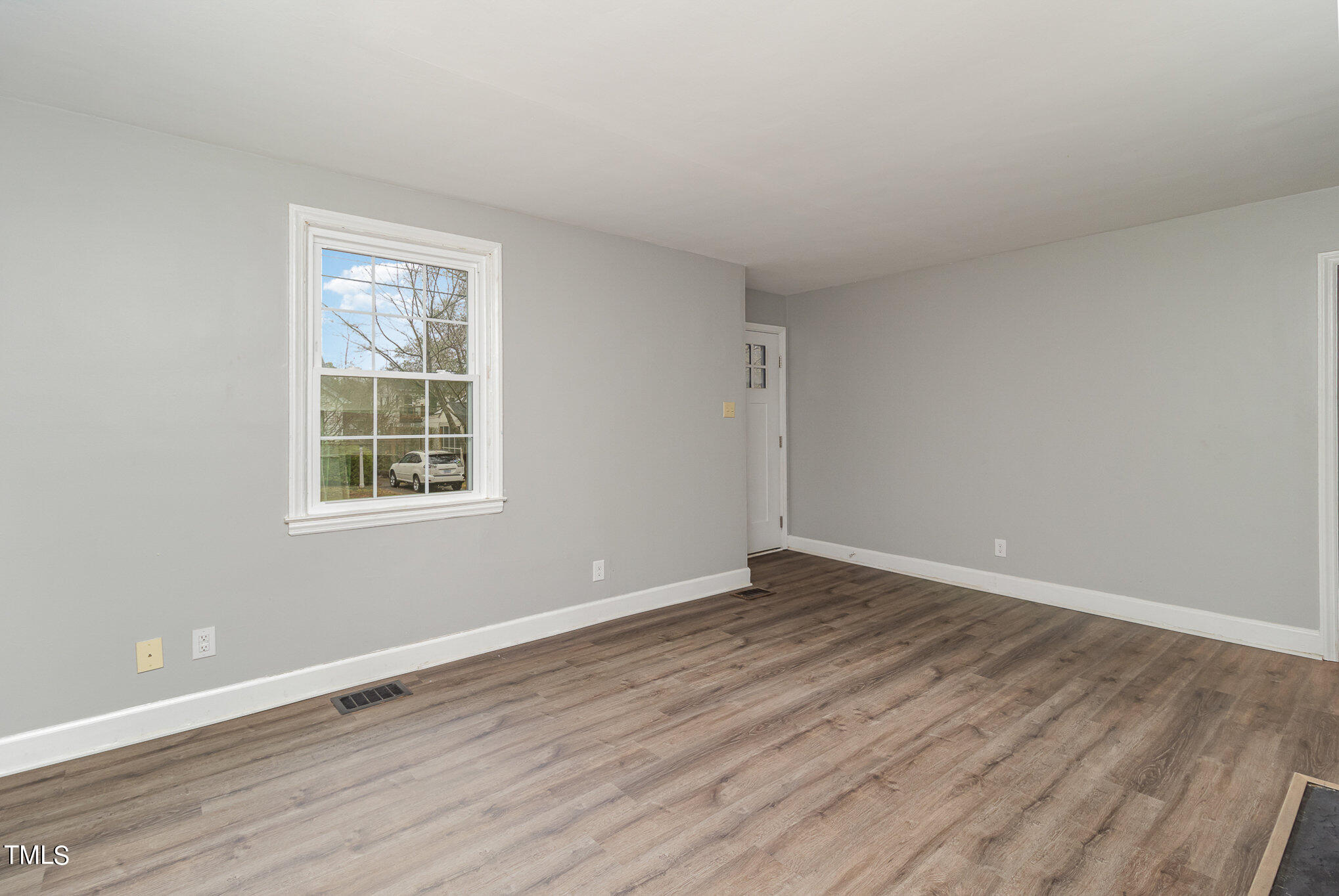 2813 Fowler Avenue Raleigh, NC 27607 - Photo 7 of 30 a view of an empty room with wooden floor and a window