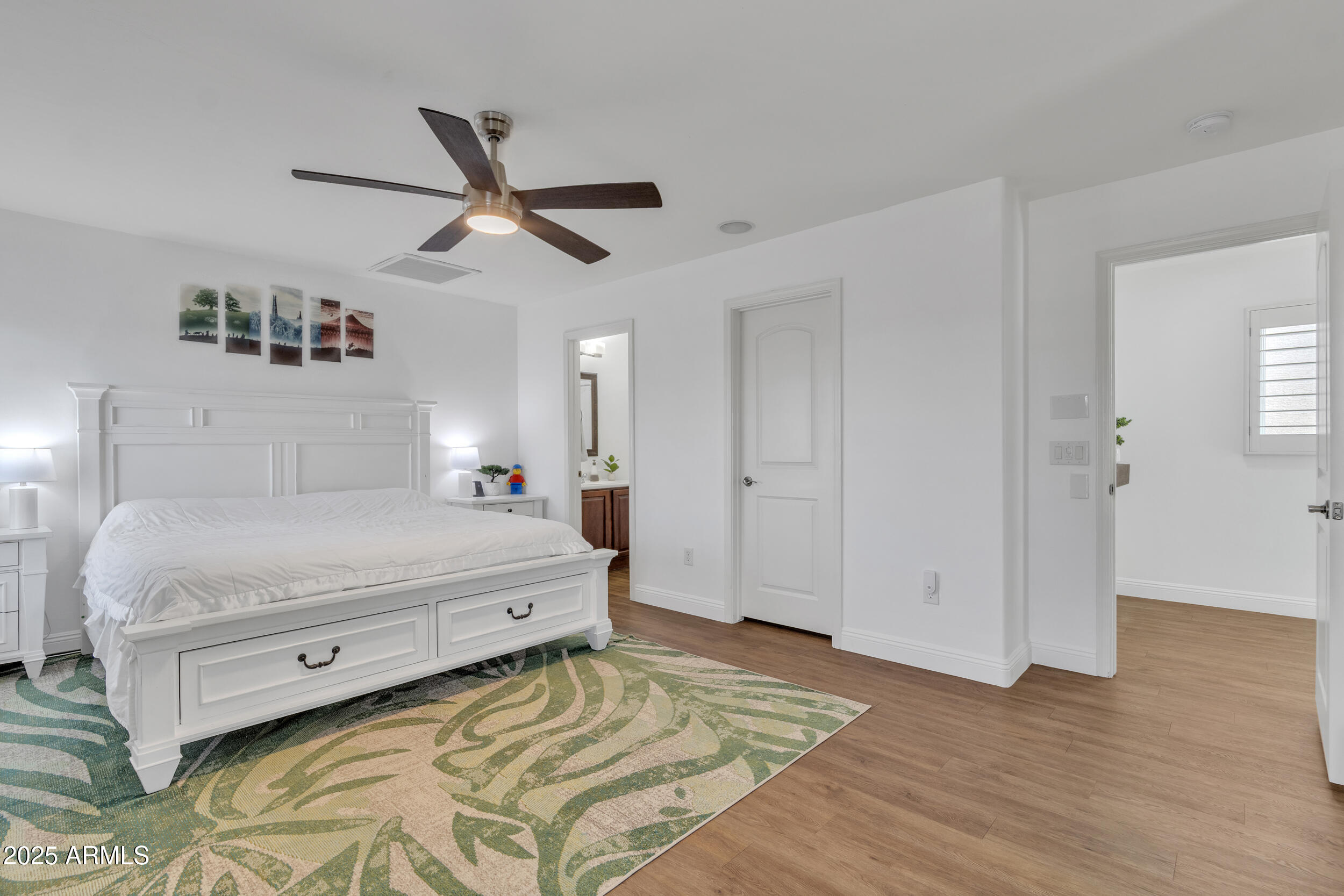 4159 East Jasper Drive Gilbert, AZ 85296 - Photo 17 of 26 a spacious bedroom with a bed and a ceiling fan