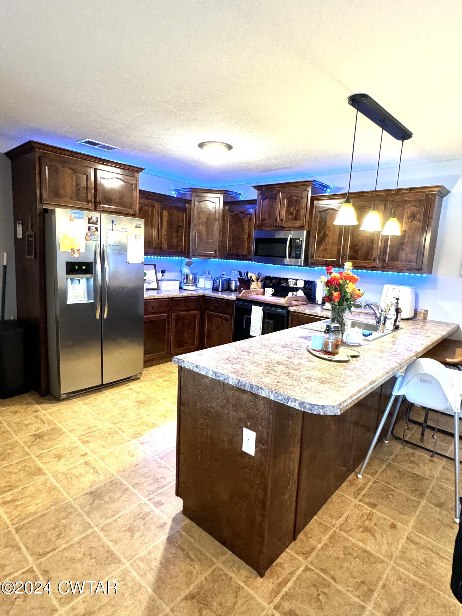 870 Simmons Road Henderson, TN 38340 - Photo 5 of 14 a kitchen with stainless steel appliances kitchen island granite countertop a sink and cabinets