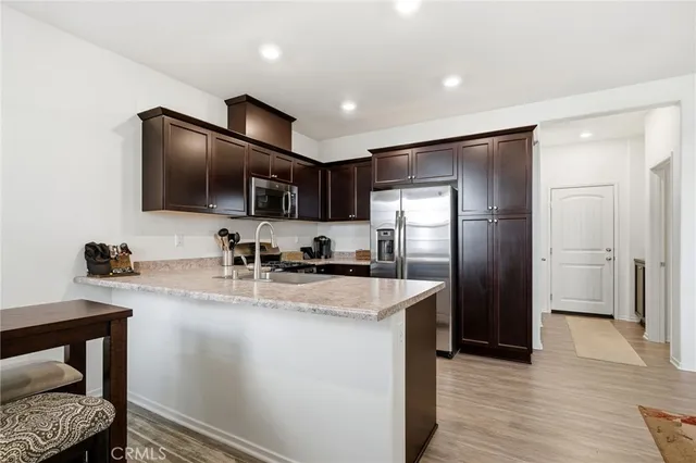 a kitchen with stainless steel appliances granite countertop a refrigerator a sink a stove a microwave and island