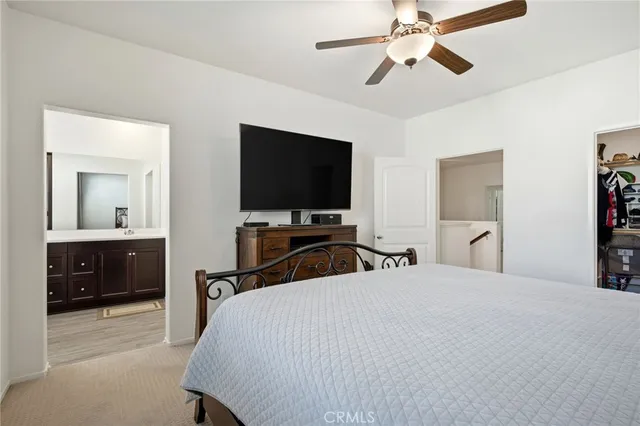 a bedroom with a bed and a flat tv screen on dresser