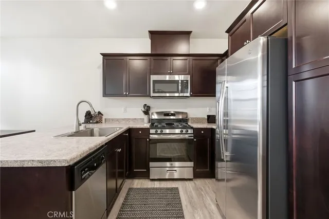 a kitchen with stainless steel appliances granite countertop a refrigerator and a sink