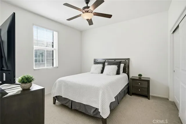 a bedroom with a bed lamp closet and window