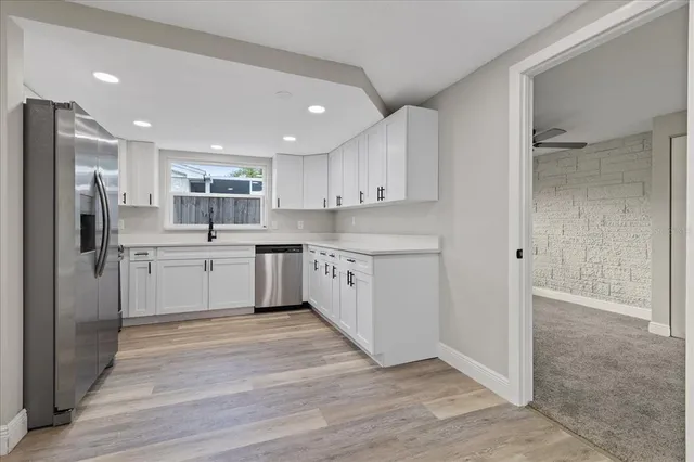 a kitchen with white cabinets stainless steel appliances and a sink