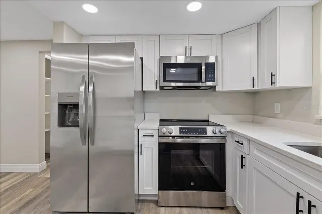 a kitchen with white cabinets and stainless steel appliances