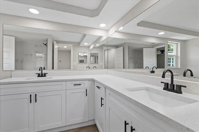 a spacious bathroom with a double vanity sink and mirror