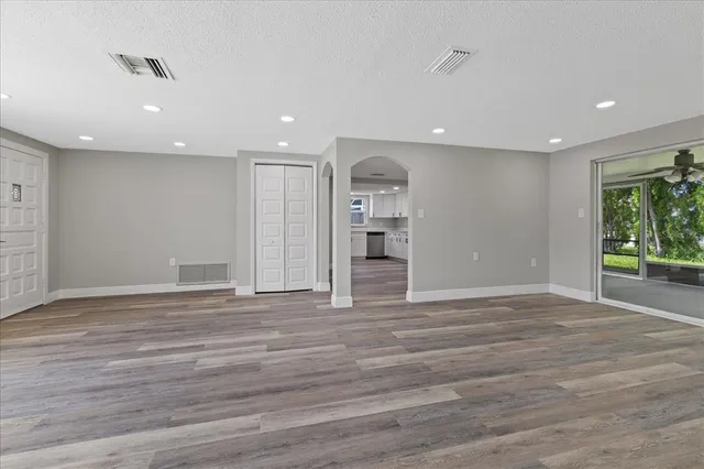 a view of empty room with wooden floor and windows