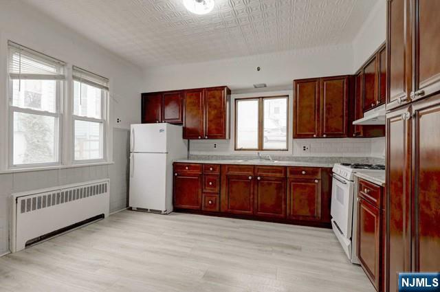 58 Westervelt Avenue, Unit 1 Hawthorne, NJ 07506 - Photo 3 of 17 a kitchen with stainless steel appliances granite countertop a refrigerator sink and wooden cabinets