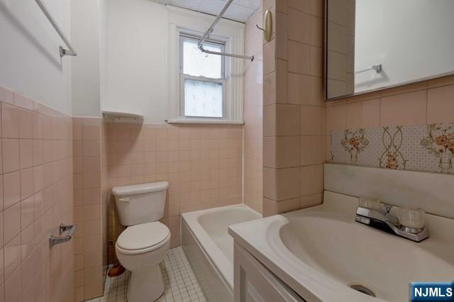 58 Westervelt Avenue, Unit 1 Hawthorne, NJ 07506 - Photo 9 of 17 a bathroom with a sink a toilet and window