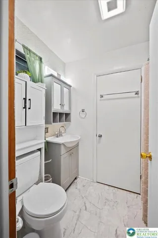 a bathroom with a toilet sink and mirror