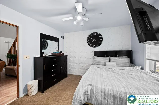 a bedroom with a bed and a mirror on dresser