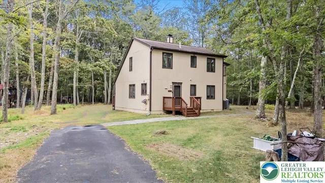a view of a house with backyard and trees