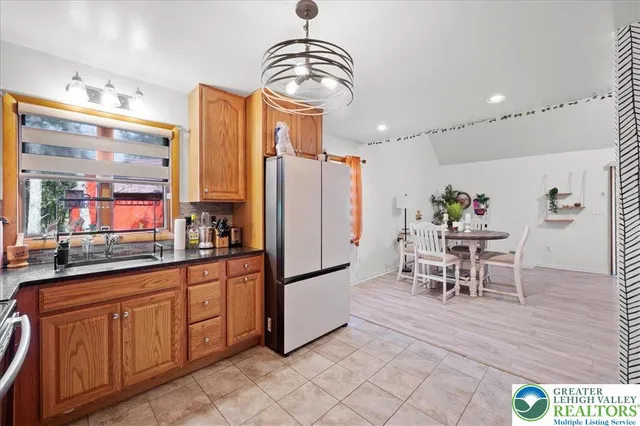 a dining hall with stainless steel appliances granite countertop a refrigerator and a stove top oven