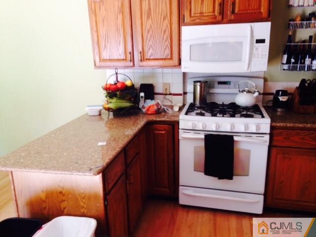 75 Rieder Road Spotswood, NJ 08884 - Photo 5 of 15 a kitchen with stainless steel appliances granite countertop a stove a sink and a microwave