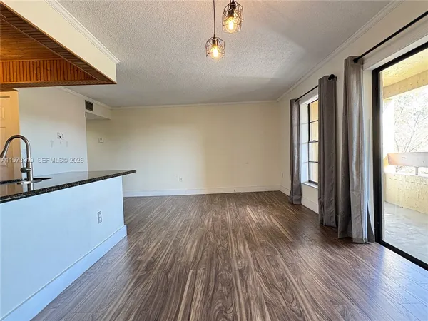 a view of a kitchen with wooden floor and a sink