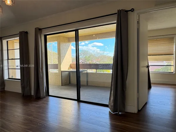 a view of a big room with wooden floor and windows