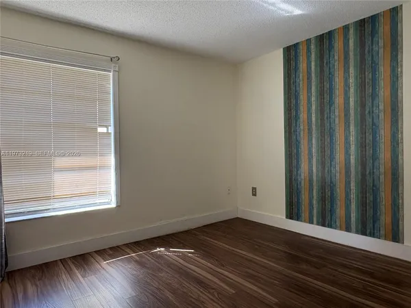 a view of a room with wooden floor and a window