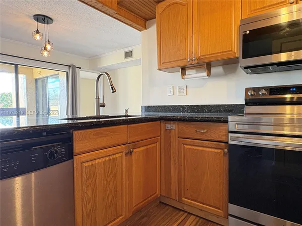 a kitchen with granite countertop stainless steel appliances and sink