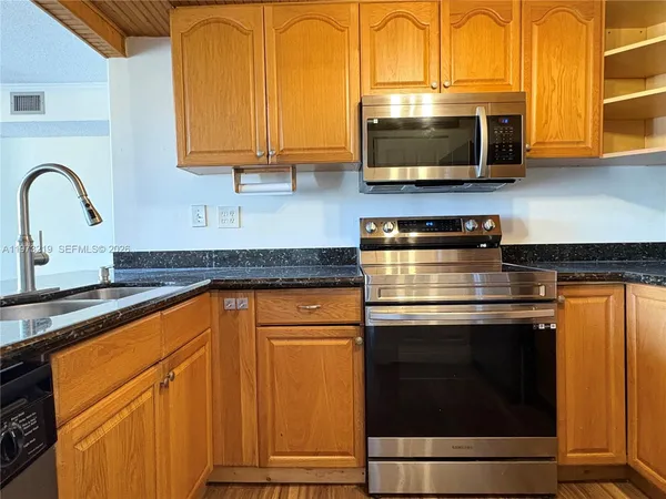 a kitchen with stainless steel appliances granite countertop a stove microwave and sink