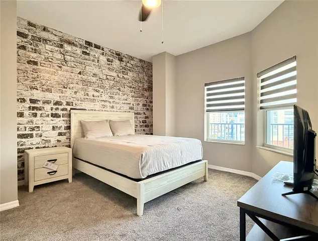 a bedroom with a large bed and a flat tv screen on dresser