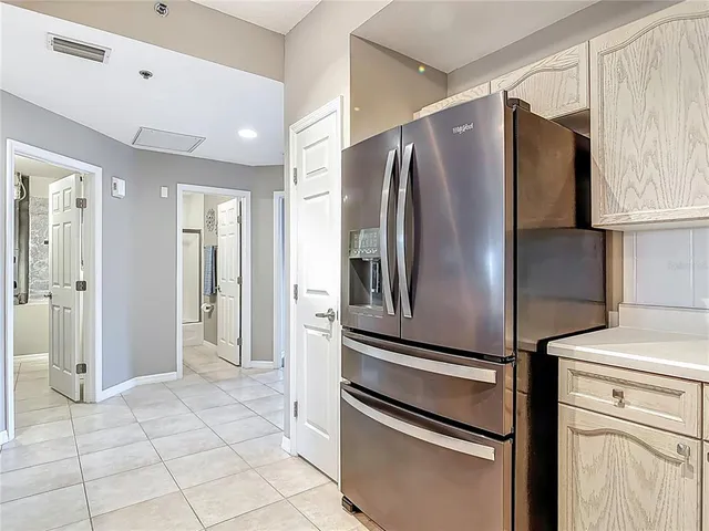 a metallic refrigerator freezer and a stove sitting inside of a kitchen
