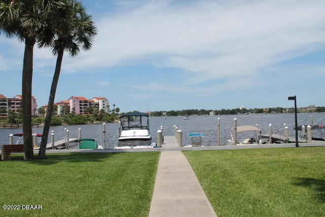 a view of a lake with a water fountain and a big yard