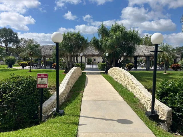 a front view of a house with garden and trees