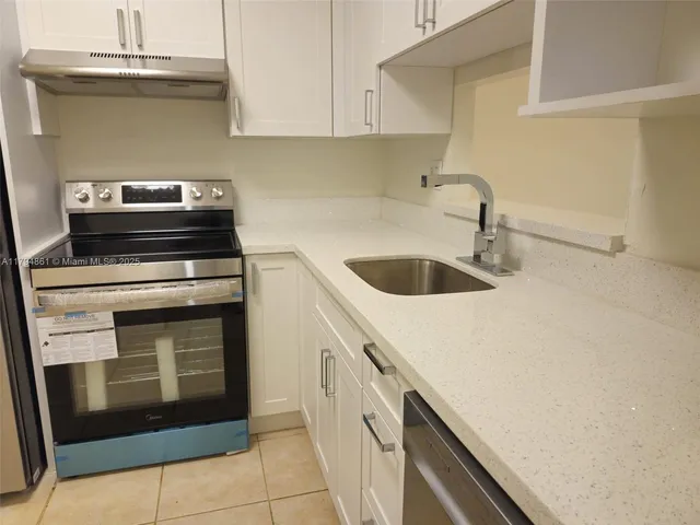 a kitchen with granite countertop a sink and cabinets