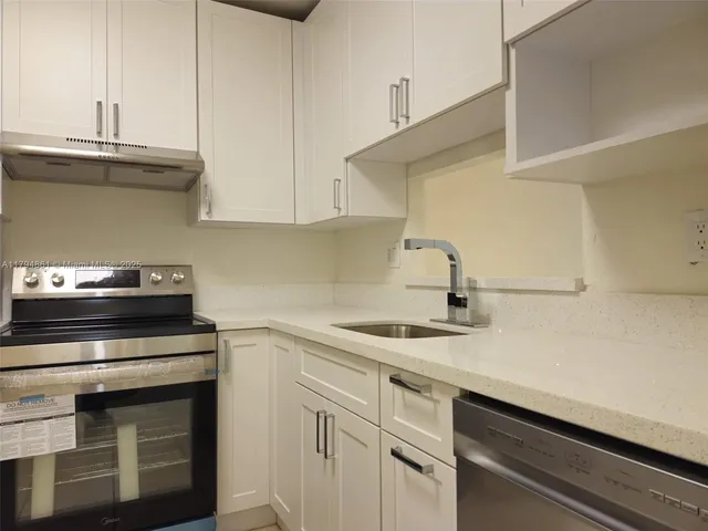 a kitchen with a sink cabinets and appliances