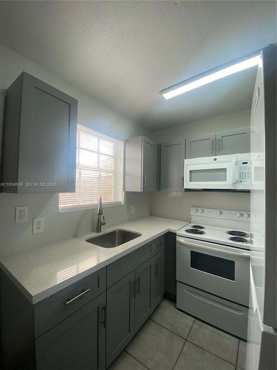 11350 Southwest 3rd Street, Unit A Sweetwater, FL 33174 - Photo 7 of 18 a kitchen with a stove sink and cabinets