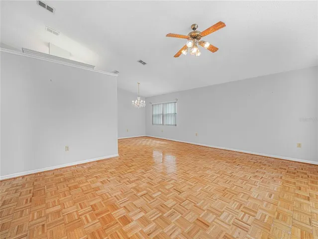 an empty room with a ceiling fan and window