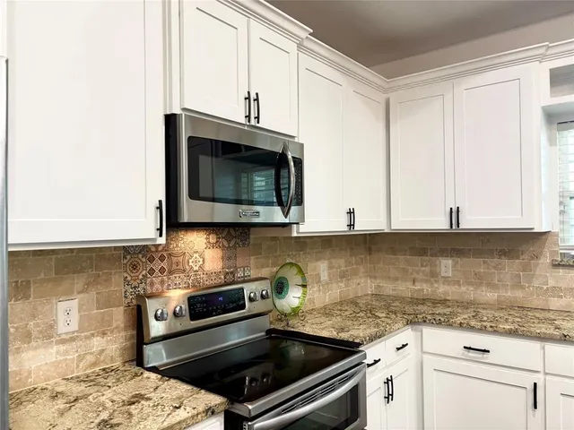 a kitchen with stainless steel appliances granite countertop a stove a microwave and cabinets