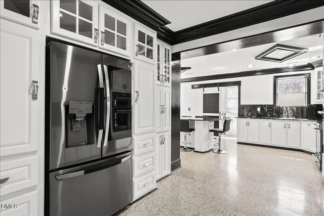 a kitchen with a refrigerator and white cabinets