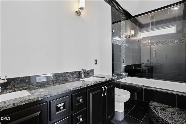 a bathroom with a granite countertop sink a toilet and shower