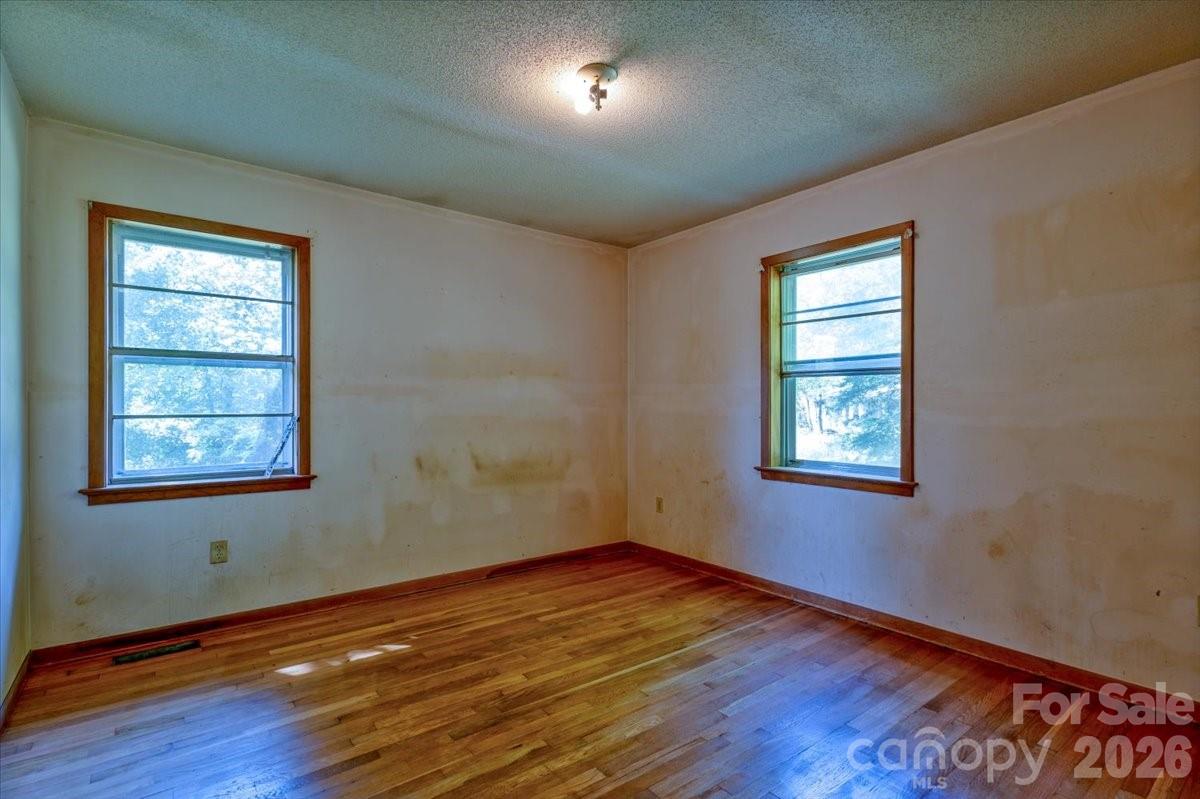 156 Old Sweetwater Road Robbinsville, NC 28771 - Photo 18 of 25 an empty room with wooden floor and windows