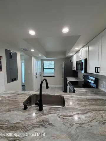 a large kitchen with a large counter top appliances and cabinets