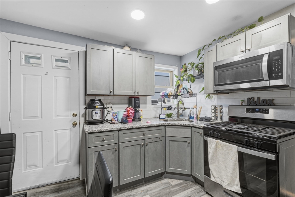144 Choate Street Fall River, MA 02723 - Photo 16 of 42 a kitchen with stainless steel appliances granite countertop a sink stove and microwave