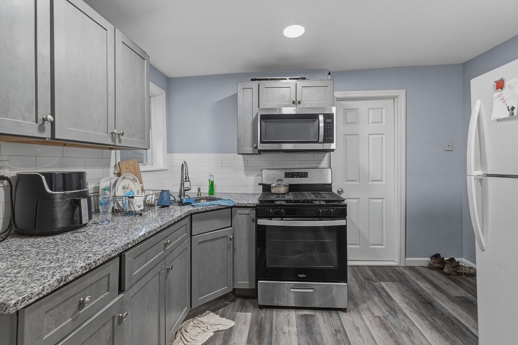 144 Choate Street Fall River, MA 02723 - Photo 36 of 42 a kitchen with granite countertop a refrigerator stove and microwave