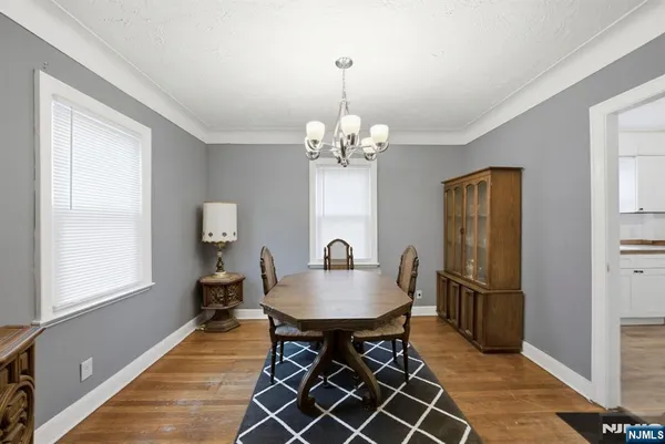 a dining room with furniture a chandelier and wooden floor