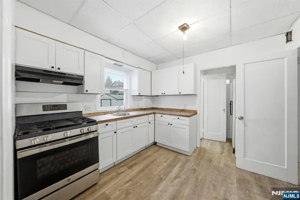 a kitchen with granite countertop a stove a sink and a refrigerator